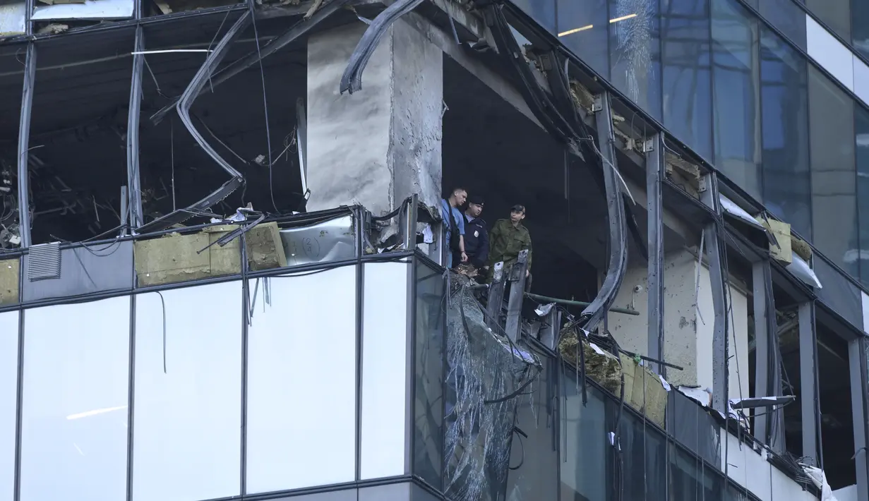 Penyelidik memeriksa gedung pencakar langit yang rusak di kawasan bisnis "Kota Moskow" setelah serangan drone yang dilaporkan di Moskow, Rusia, Minggu dini hari (30/7/2023). (AP Photo)