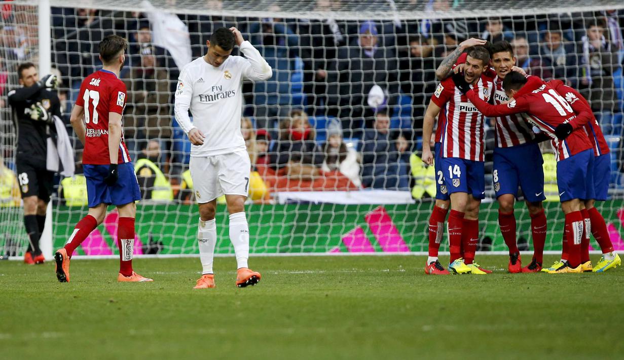 Pemain Real Madrid, Cristiano Ronaldo berjalan dianatara perayaan kemenangan para pemain Atletico Madrid usai kalah 0-1 pada Laga Lanjutan La Liga Spanyol pekan ke-26 di Stadion Santiago Bernabeu, Sabtu (27/2/2016) Malam WIB. (REUTERS/Sergio Perez)