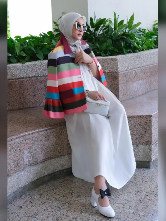 Kali ini, Syahrini memberikan sentuhan playful lewat outerwear warna-warni yang dikenakan di atas maxi dress putihnya. [@princessyahrini]