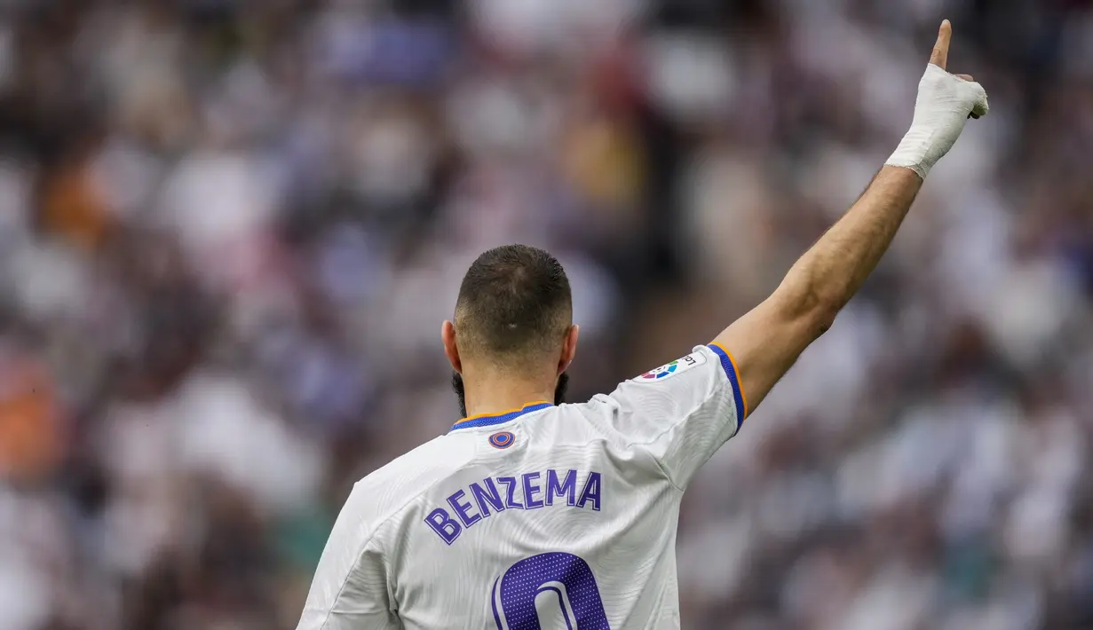<p>Penyerang Real Madrid, Karim Benzema melakukan selebrasi usai mencetak gol ke gawang Espanyol pada pertandingan lanjutan La Liga Spanyol di stadion Santiago Bernabeu di Madrid, Sabtu (30/4/2022). Real Madrid menang atas Espanyol 4-0. (AP Photo/Bernat Armangue)</p>