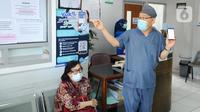 Dokter Desman Siahaan memberikan sosialisasi langsung mengenai tata cara rumah sakit rujukan kepada pasien BPJS Kesehatan yang sedang antre berobat di Faskes Tingkat 1 Klinik Kesehatan Prima Husada di Depok, Jawa Barat, Senin (23/5/20222). Sejumlah terobosan saat ini dilakukan paramedis di Faskes Tingkat 1, diantaranya penilaian peserta program JKN melalui fitur Kessan (Kesan Pesan Peserta Setelah Layanan)  dalam aplikasi Mobile JKN. (merdeka.com/Arie Basuki)