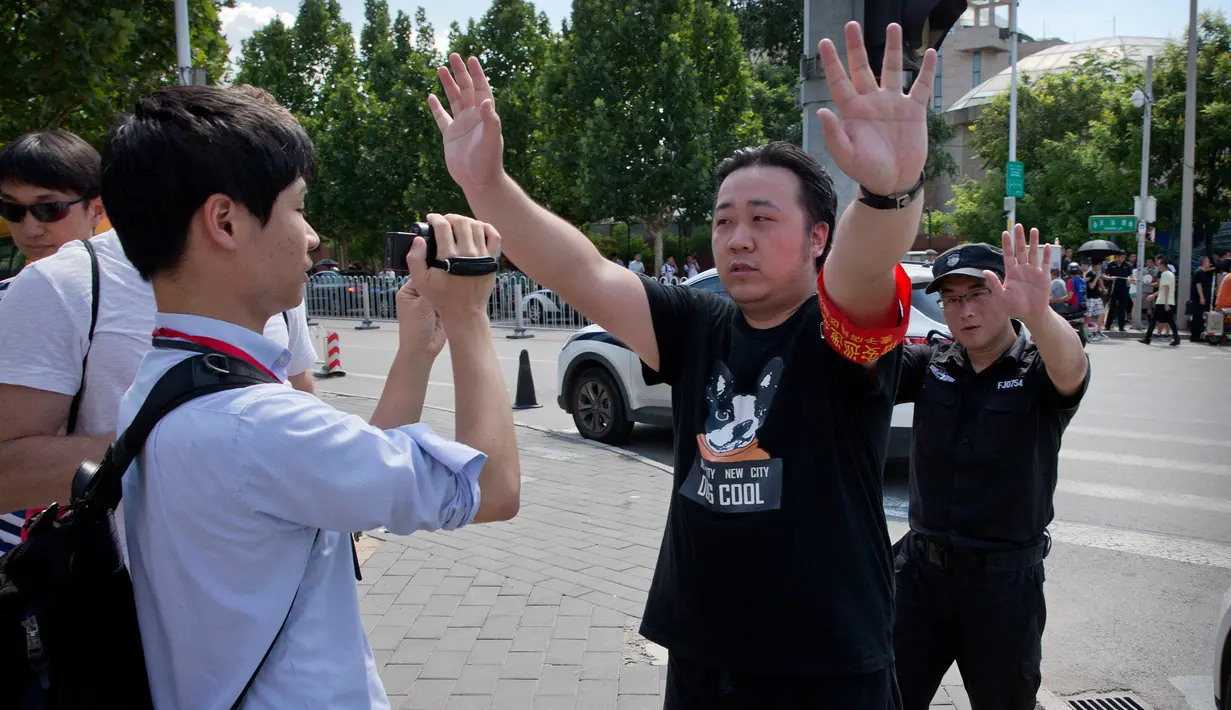 Pejabat China berusaha menghalangi jurnalis yang mengambil gambar dekat lokasi ledakan di kedutaan besar Amerika Serikat di Beijing, Kamis (26/7). Sejauh ini belum diperoleh komentar dari pemerintah China maupun kedutaan besar AS. (AP/Mark Schiefelbein)