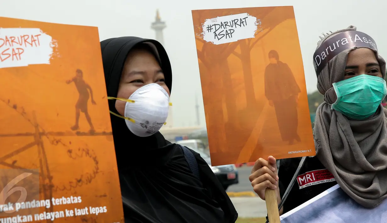 Massa dari Aksi Cepat Tanggap (ACT) mengusung sejumlah poster saat aksi menolak asap di Patung Kuda, Jakarta, Senin (26/10). Aksi itu menuntut elemen masyarakat agar terlibat langsung dalam upaya penuntasan masalah asap. (Liputan6.com/Faizal Fanani)