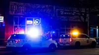 Kendaraan polisi berjaga di luar toko tato Sol Tribe di Broadway di mana dua wanita tewas ditembak dan seorang pria terluka di Denver, Colorado (27/12/2021). Polisi Denver sedang menyelidiki dua penembakan terpisah pada Senin malam. (Michael Ciaglo/Getty Images/AFP)