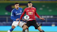 Striker Manchester United, Mason Greenwood (kanan), menguasai bola dibayangi gelandang Everton, Ben Godfrey, dalam laga perempatfinal Piala Liga Inggris Carabao Cup di Goodison park, Rabu (23/12/2020). Manchester United menang 2-0 atas Everton. (AFP/Nick Potts/Pool)