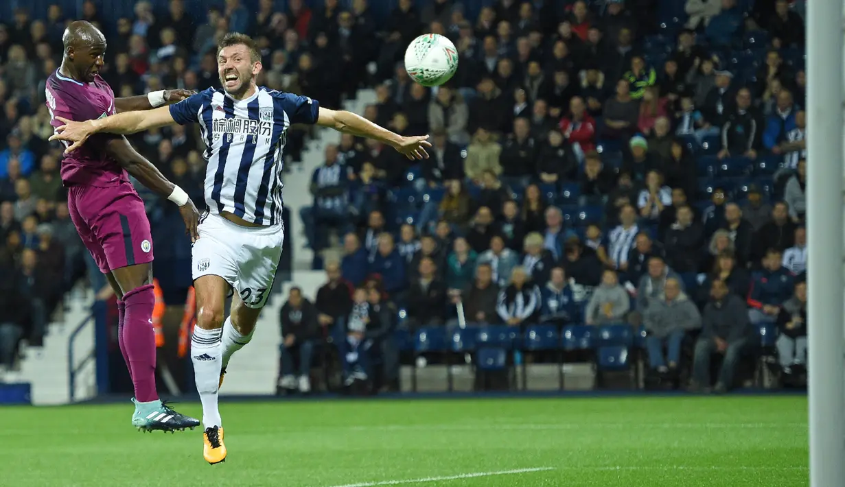 Pemain Manchester City, Eliaquim Mangala (kiri) menyundul bola melewati adangan pemain West Bromwich, Gareth McAuley pada laga Piala Liga Inggris di The Hawthorns, West Bromwich, (20/9/2017). City menang 2-1.  (AFP/Oli Scarff)
