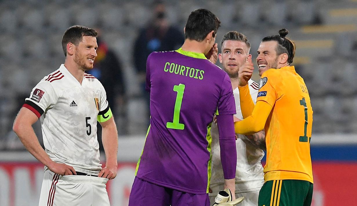 Kiper Belgia, Thibaut Courtois, bercengkrama dengan penyerang Wales, Gareth Bale, pada laga Kualifikasi Piala Dunia 2022 di Stadion Den Dreef, Kamis (25/3/2021). Belgia menang dengan skor 3-1. (AFP/John Thys)