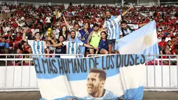 Suporter Timnas Argentina membentangkan spanduk bergambar Lionel Messi saat menyaksikan laga melawan Timnas Indonesia pada FIFA Matchday 2023 di Stadion Utama Gelora Bung Karno, Jakarta, Senin (19/6/2023). (Bola.com/Bagas Lazuardi)