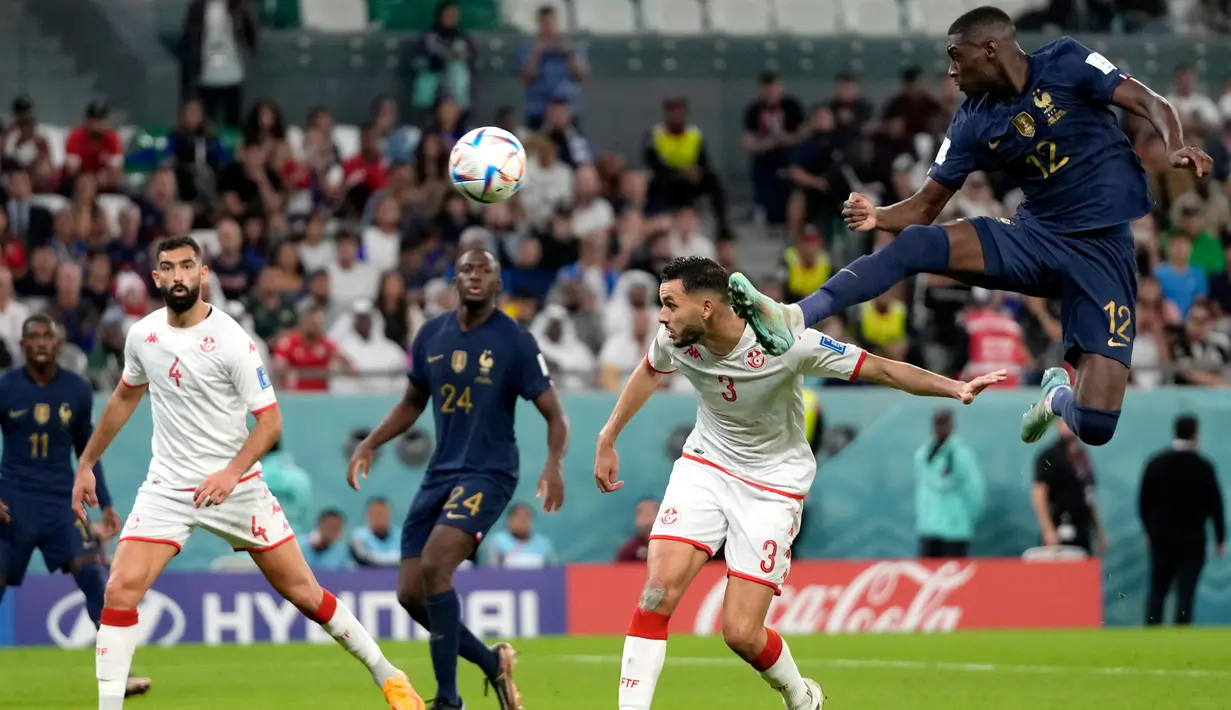 Pemain Prancis Ranald Kolo Muani (kanan) melompat untuk merebut bola saat melawan Tunisia pada pertandingan sepak bola Grup D Piala Dunia 2022 di Stadion Education City, Al Rayyan, Qatar, 30 November 2022. Prancis menjuarai Grup D Piala Dunia 2022 meski kalah dari Tunisia 1-0. (AP Photo/Frank Augstein)