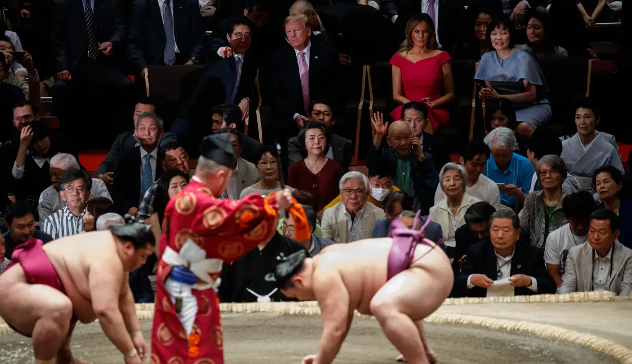 Presiden AS Donald Trump (dua kiri) berbincang dengan PM Jepang Shinzo Abe (kiri) saat menyaksikan Tokyo Grand Sumo Tournament di Stadion Ryogoku Kokugikan, Tokyo, Jepang, Minggu (26/5/2019). Nonton bareng ini dilakukan di sela-sela kunjungan kenegaraan Trump ke Jepang. (AP Photo/Evan Vucci)