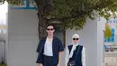 Manisnya penampilan pasutri Rey Mbayang dan Dinda Hauw di foto ini. Rey Mbayang tampil dengan kaus putih polos dengan padu padan top biru navy yang serasi dengan celana panjangnya. Sedangkan Dinda tampil cantik dengan manset putih yang ditumpuknya dengan dress panjang tanpa lengan berwarna biru navy dan hijab putih polos. [Foto: Instagram/rey_mbayang]