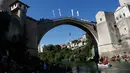 Penonton menyaksikan peserta melompat dari jembatan Mostar pada kompetisi menyelam tradisional ke 451 di Mostar, Bosnia, Minggu (30/7). Para peserta dari Bosnia dan negara tetangga itu melakukan lompatan dari ketinggian 25 meter. (AP Photo/Amel Emric)