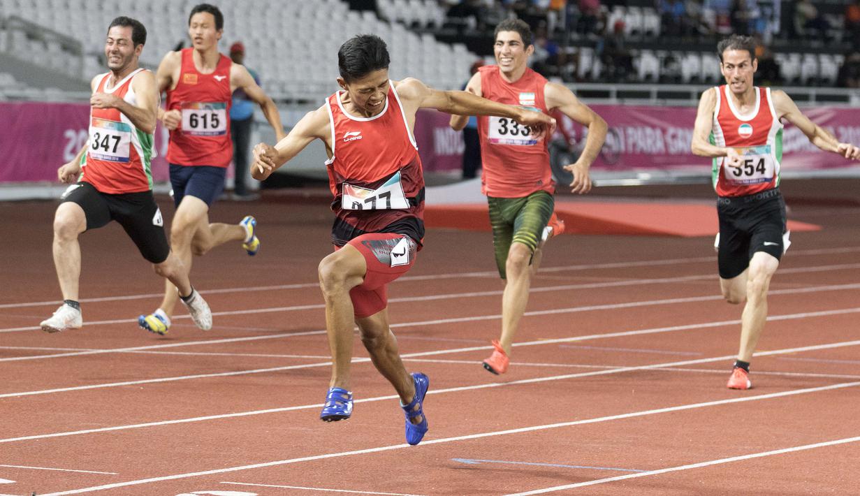 Purnomo Sapto Yogo pelari Indonesia meraih medali emas di nomor 100 meter putra klasifikasi T37 pada Asian Para Games 2018, di Stadion Utama Gelora Bung Karno Jakarta, Selasa (9/10/2018).  (Bola.com/Peksi Cahyo)