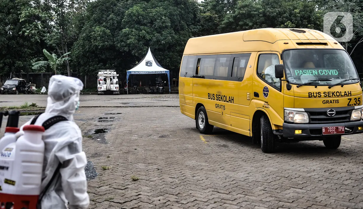 Petugas bersiap melakukan dekontaminasi sopir bus sekolah usai mengangkut pasien Covid-19 di Pool Unit Pelayanan Angkutan Sekolah (UPAS) DKI Jakarta, Kramat Jati, Selasa (5/1/2021). Para sopir bus sekolah itu rutin melakukan dekontaminasi hingga mengganti pakaian hazmat. (merdeka.com/Iqbal Nugroho)
