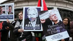 Para pengunjuk rasa memegang papan-papan saat unjuk rasa menuntut pembebasan pendiri Wikileaks, Julian Assange, di Place de la Republique, Paris, 20 Februari 2024. (Thomas SAMSON/AFP)