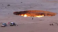 Sebuah gambar yang diambil pada 3 Mei 2014, menunjukkan orang-orang mengunjungi "The Gateway to Hell," sebuah kawah gas besar yang terbakar di jantung gurun Karakum, Turkmenistan. (AFP)