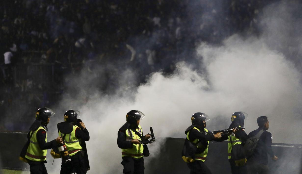 Tetapi pihak keamanan melakukan kebijakan yang kontroversial. Mereka justru menggunakan gas air mata untuk membubarkan massa yang terus merengsek ke dalam lapangan. Langkah tersebut justru membuat kondisi di lapangan makin runyam. (AP/Yudha Prabowo)