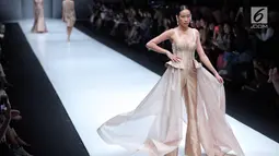 Model berpose diatas catwalk mengenakan rancangan desainer Cherryn Lim dalam ajang JFW 2018 di Senayan City, Jakarta, Kamis (26/10). Dalam rancangannya material yang digunakan bahan yang lembut, semi transparent dan glittery. (Liputan6.com/Faizal Fanani)