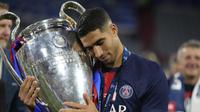Achraf Hakimi dari PSG mengangkat trofi juara Champions League usai final kontra Inter Milan di Allianz Arena, Munich, Jerman, Sabtu, 31 Mei 2025. (AP Photo/Luca Bruno)