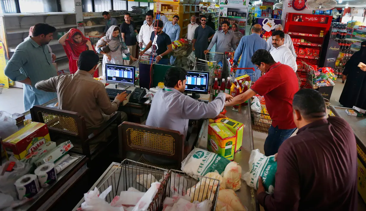Pembeli antre menunggu untuk membayar belanjaan mereka di supermarket yang dikelola pemerintah Pakistan di Islamabad, Rabu (16/5). Warga berbelanja untuk berbagai persiapan Puasa Ramadan yang dimulai pada Kamis (17/5). (AP/Anjum Naveed)