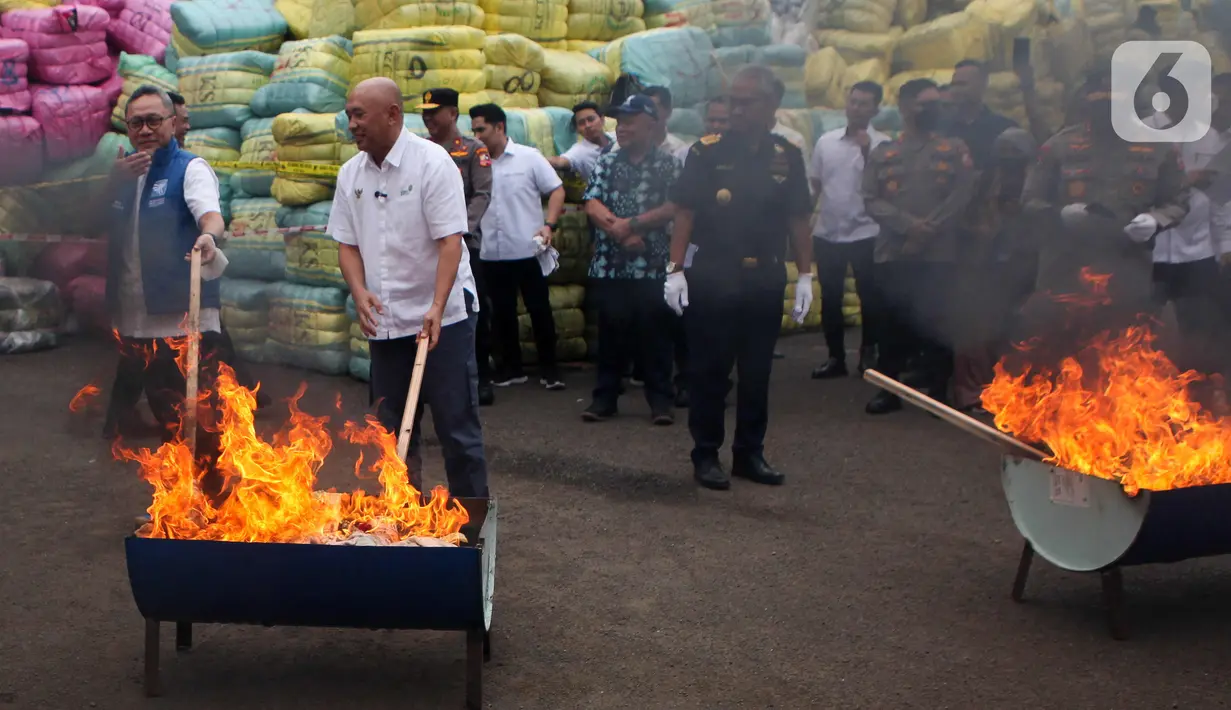 Menteri Perdagangan Zulkifli Hasan melakukan pemusnahan barang bukti pakaian bekas di Tempat Penimbunan Pabean (TPP) Cikarang, Kabupaten Bekasi, Jawa Barat, Selasa (28/3/2023). (Liputan6.com/Herman Zakharia)