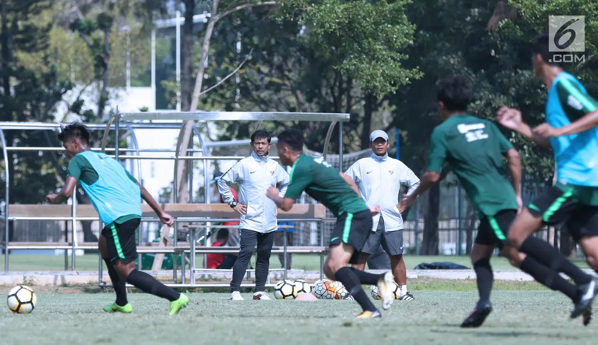 Pelatih Timnas Indonesia U-19, Indra Sjafri (kedua kiri) melihat latihan anak didiknya di Lapangan B Kompleks GBK, Jakarta, Selasa (18/9). Latihan ini persiapan  PSSI Anniversary Cup U-19 dan Piala AFC U19. (Liputan6.com/Helmi Fithriansyah)