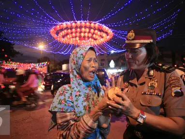 Seorang Polwan membagikan kue keranjang kepada pengguna jalan yang melintas di Pasar Gede, Solo (8/2). Pembagian kue keranjang imlek bertujuan mengkampanyekan anti narkoba dengan slogan, Kue Keranjang Lebih Manis Dari Narkoba. (Liputan6.com/Boy Harjanto)