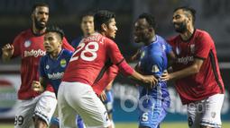 Gelandang Persib Bandung, Michael Essien, dihentikan para pemain Bali United saat ingin mengejar Yabes Roni. Mantan pemain Chelsea itu kesal karena Yabes Roni menendang bola secara keras ke arahnya. (Bola.com/Vitalis Yogi Trisna)