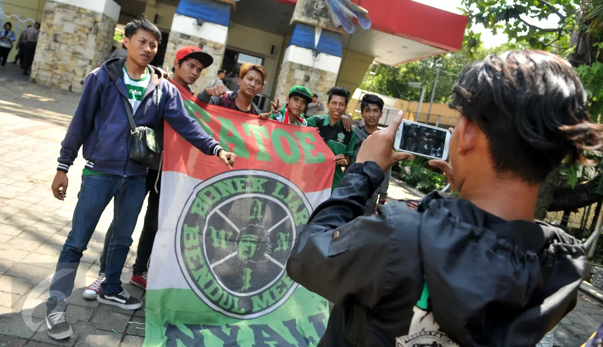 Bonek 1927, suporter klub sepak bola Persebaya Surabaya, berfoto di depan lokasi berlangsungnya KLB PSSI di Ancol, Jakarta, Rabu (3/8). Para Bonek menuntut tim kesayangannya, Persebaya, untuk bisa tampil dikompetisi resmi. (Liputan6.com/Gempur M Suray)