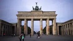 Wisatawan berkumpul di depan Gerbang Brandenburg yang terkenal di Jerman yang ditutupi sisa-sisa cat oranye di Berlin, Minggu, 1 Oktober 2023. (AP Photo/Markus Schreiber)