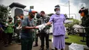 Warga menerima nasi kotak serta masker dari TNI di Markas Komando Gabungan Wilayah I, Jakarta, Selasa (21/4/2020). Dalam rangka Hari Kartini, TNI membagikan makanan dan masker kepada masyarakat. (Liputan6.com/Faizal Fanani)