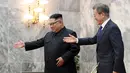Pemimpin Korut Kim Jong-un mempersilahkan Presiden Korsel Moon Jae-in saat menyambutnya di Panmunjom, Korea Utara (26/5). Mereka bertemu di zona demiliterisasi yang memisahkan kedua negara. (South Korea Presidential Blue House/Yonhap via AP)