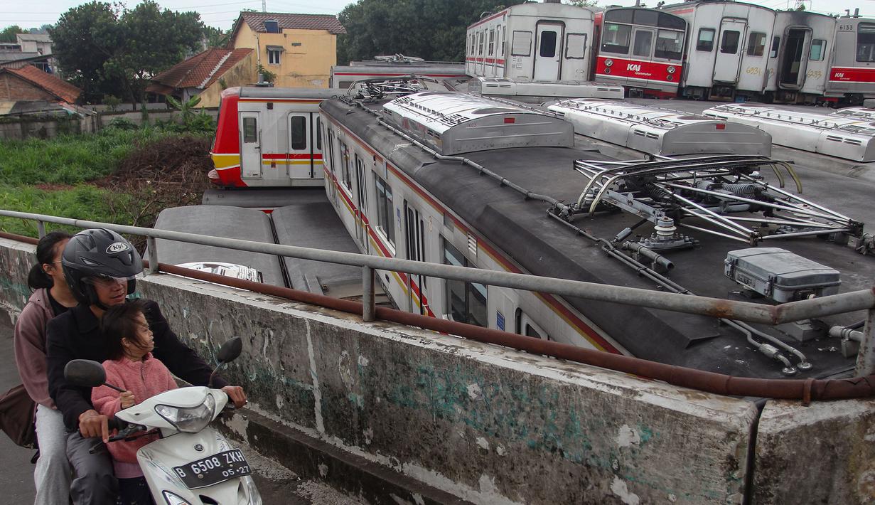 Ratusan gerbong tersebut tidak lagi masuk kualifikasi untuk dapat dioperasikan. Tampak dalam foto, warga melintas di jalan layang dekat Depo Kereta Rel Listrik (KRL) di Jalan Kampung Rawageni, Cipayung, Kota Depok, Jawa Barat, Selasa (20/01/2026). (Merdeka.com/Arie Basuki)