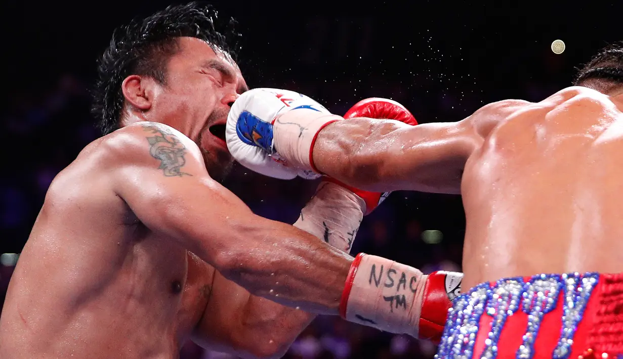 Petinju Manny Pacquiao mendapat pukulan dari Keith Thurman dalam pertarungan gelar tinju Super World kelas Welter WBA di MGM Garden Arena, Las Vegas, Sabtu (20/7/2019). Manny Pacquiao merebut sabuk juara WBA Super kelas welter dengan skor 115-112, 115-112, dan 113-114. (AP/John Locher)