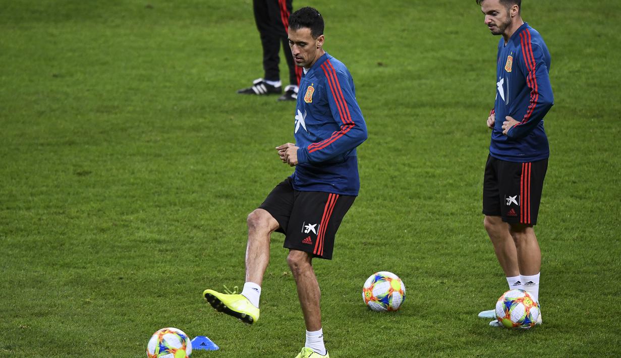 Gelandang Spanyol, Sergio Busquets (kiri) menendang bola saat latihan tim di Solna, Swedia (14/10/2019). Spanyol akan bertanding melawan Swedia pada Grup F Kualifikasi Piala Eropa 2020 di Stadion Friends Arena. (AFP Photo/Jonathan Nackstrand)