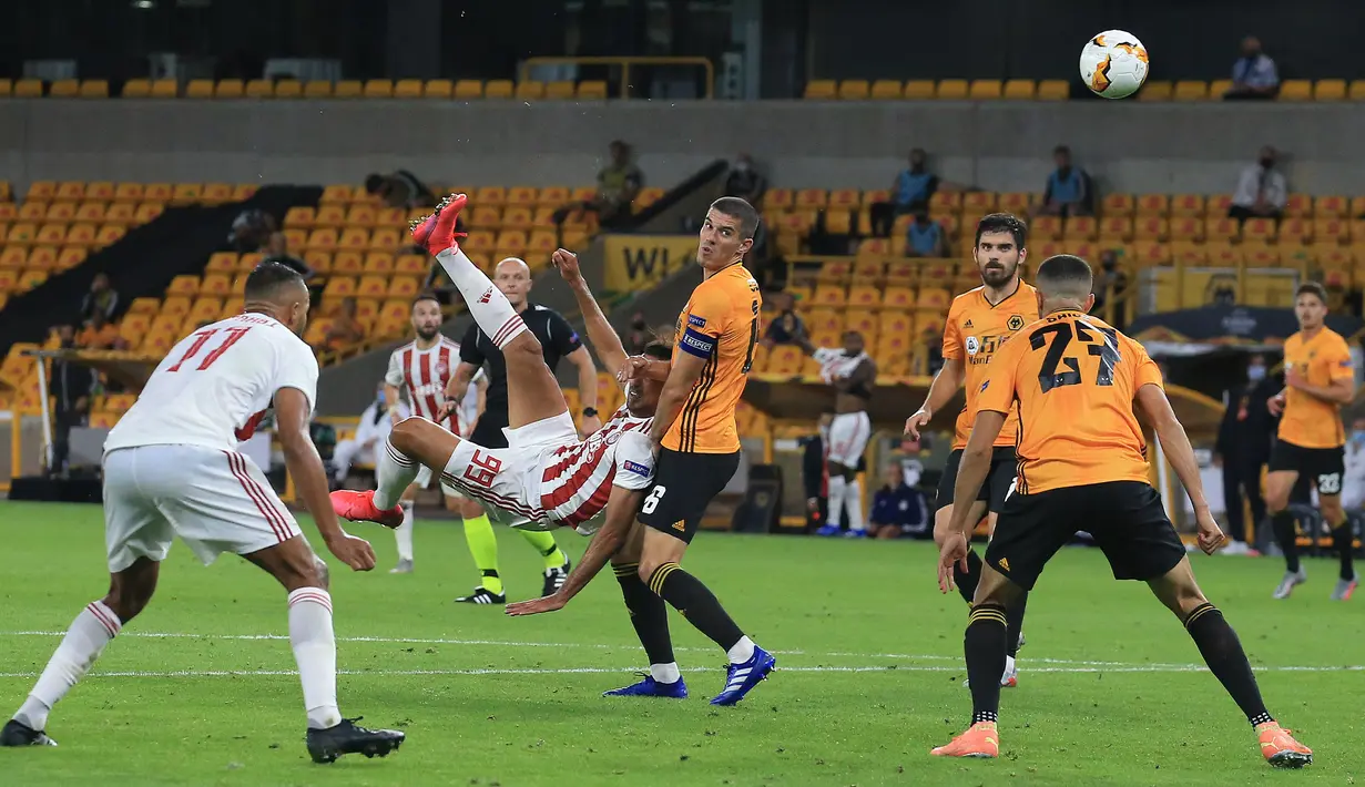 Striker Olympiacos, Ahmed Hassan, melepaskan tendangan saat menghadapi Wolverhampton Wanderers pada laga leg kedua babak 16 besar Liga Europa 2019/2020 di Molineux Stadium, Jumat (7/8/2020) dini hari WIB. Wolverhampton menang 1-0 atas Olympiacos. (AFP/Lindsey Parnaby)