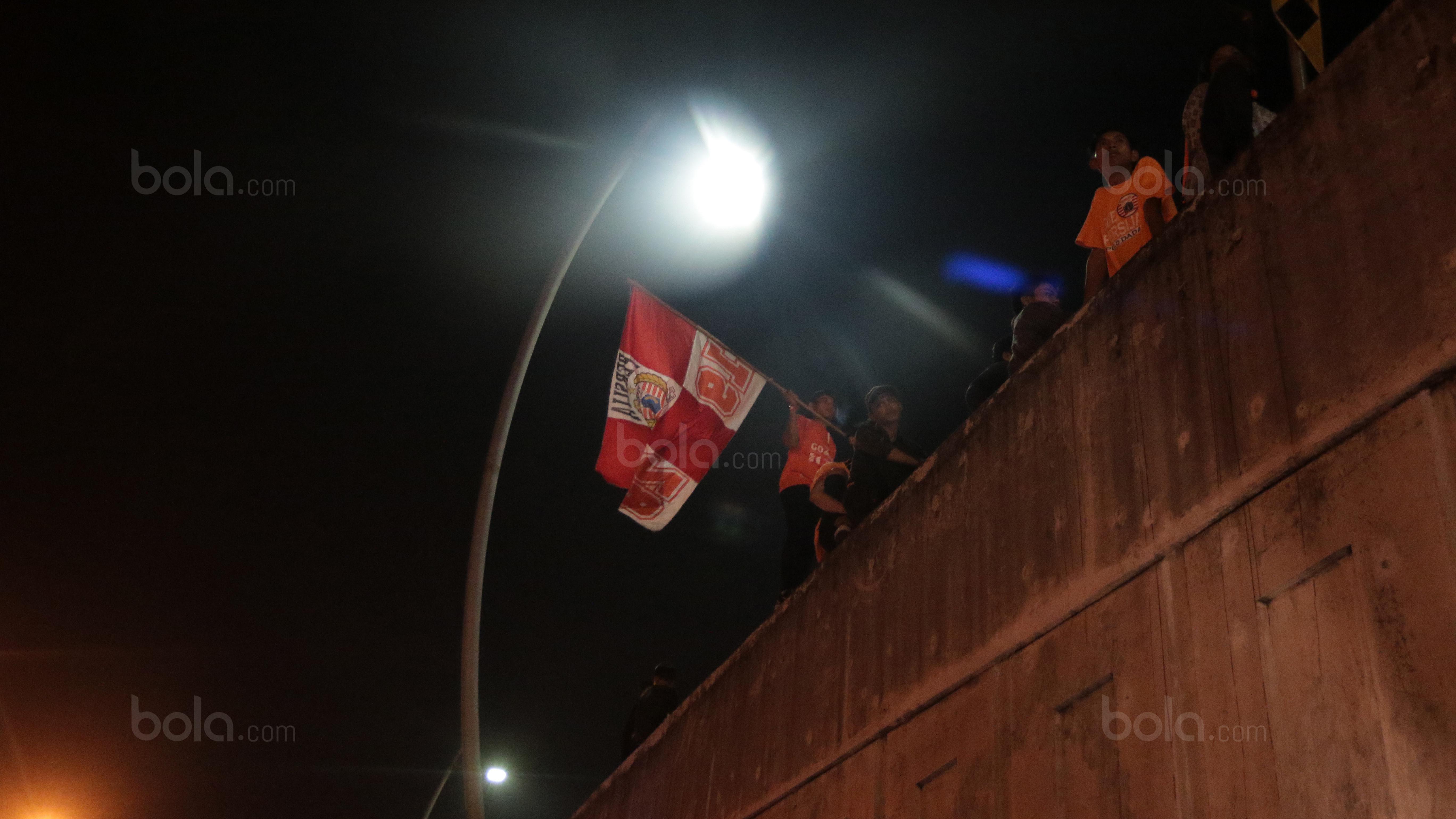 Beberapa pemuda bernyanyi dan mengibarkan bendera. (Bola.com/Nicklas Hanoatubun)