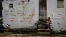 Seorang pria duduk di depan sebuah rumah yang rusak akibat tanah longsor pada malam hari di komunitas Jardim Monte Verde, lingkungan Ibura, di Recife, Negara Bagian Pernambuco, Brasil (29/5/2022). Hujan deras yang melanda negara bagian Pernambuco di timur laut Brasil menewaskan 34 orang. (AFP/Brenda Alcantara)