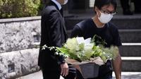 Seorang perwakilan toko bunga membawa bunga belasungkawa di kediaman mantan Perdana Menteri Jepang Shinzo Abe di Tokyo. (Foto AP/Eugene Hoshiko)