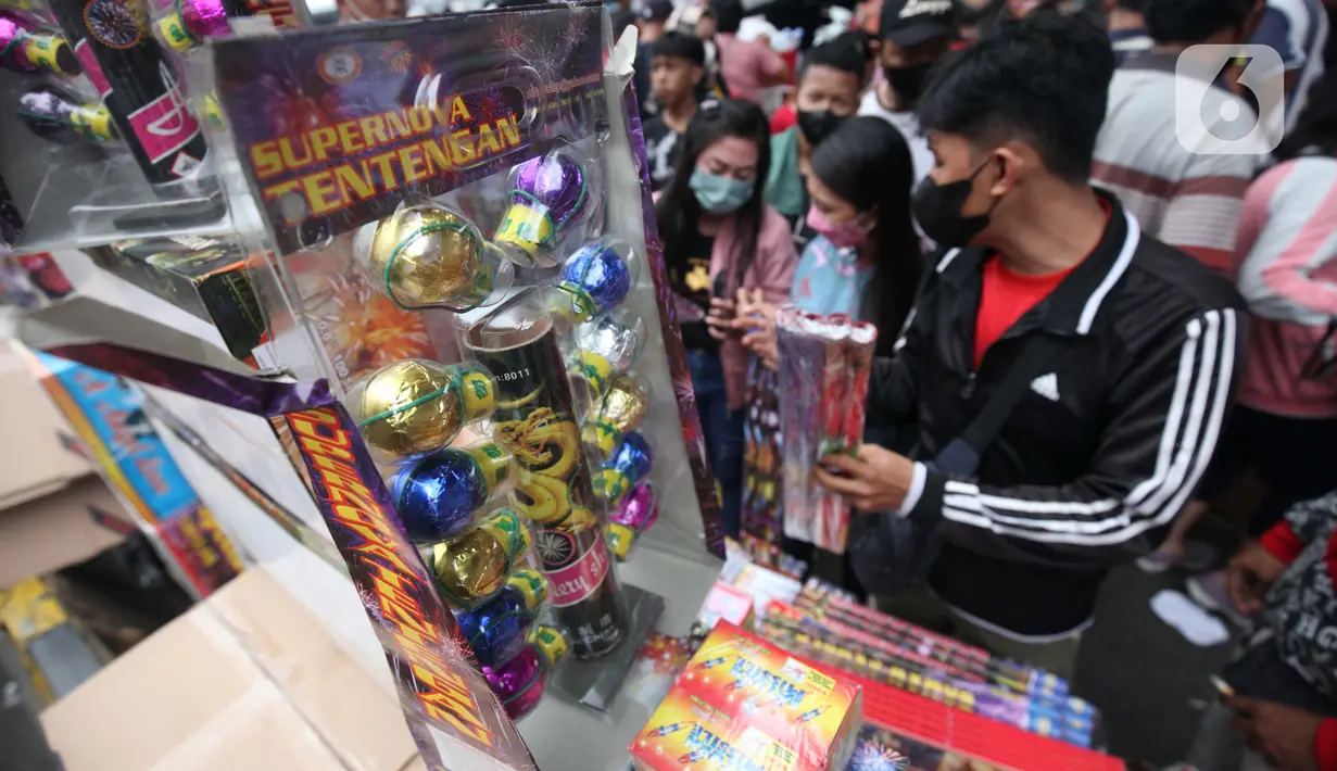 Warga membeli kembang api yang dijual oleh pedagang di Pasar Asemka, Jakarta, Kamis (30/12/2021). Meski Larangan Tahun Baru 2022 diberlakukan untuk membatasi mobilitas, namun masih banyak warga yang berburu kembang api baik untuk dijual maupun digunakan sendiri. (Liputan6.com/Johan Tallo)
