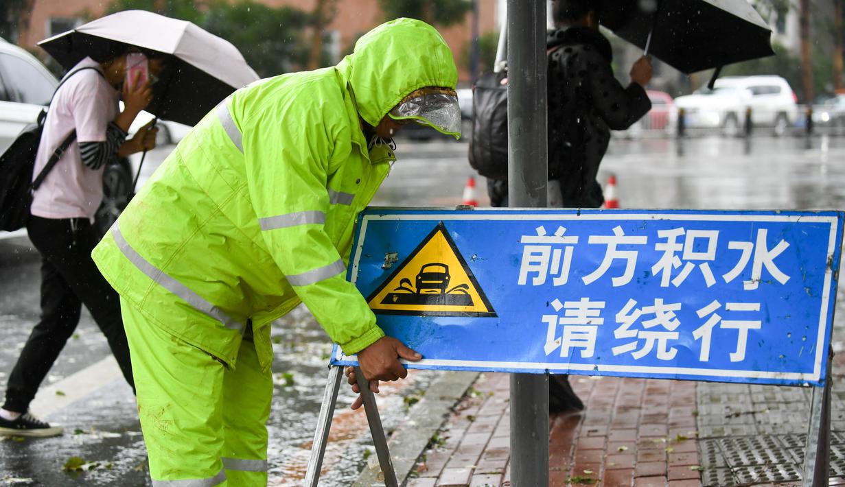 Staf memasang tanda peringatan di jalan yang tergenang air usai hujan badai akibat Topan Haishen di Changchun, Provinsi Jilin, China, 8 September 2020. Hujan deras yang dipicu Topan Haishen diperkirakan terjadi di sejumlah besar kawasan China timur laut selama dua hari ke depan. (Xinhua/Yan Linyun)
