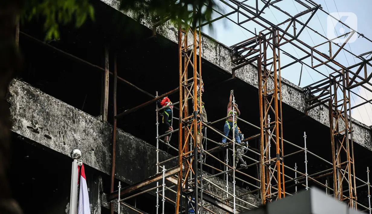 Pekerja memasang 'scaffolding' atau struktur besi untuk melakukan perbaikan Gedung Kejaksaan Agung, Jakarta, yang hangus terbakar, Rabu (7/10/2020).  DPR RI menyepakati penambahan anggaran Kejagung sebesar Rp 350 miliar untuk merenovasi gedung utama yang terbakar hebat. (Liputan6.com/Faizal Fanani)