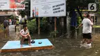 Warga menarik perahu darurat di sekitar Rumah Susun (Rusun) Bumi Cengkareng Indah (BCI), Jakarta Barat, Kamis (30/1/2025). (Magang/Liputan6.com/Muhammad Rizal)