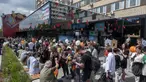 Warga berbaris untuk mengunjungi restoran cepat saji yang baru dibuka di bekas gerai McDonald's di Bolshaya Bronnaya Street, Moskow, Rusia, 12 Juni 2022. Papan itu bertuliskan 'Nama Berubah, Cinta Tetap'. (AP Photo/Dmitry Serebryakov)