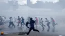 Pengunjuk rasa berlari menghindari gas air mata yang disemprotkan petugas saat bentrok di Nairobi, Kenya (16/5/2016). Mereka menuntut pembubaran otoritas pemilu karena adanya dugaan korupsi. (REUTERS/Goran Tomasevic)