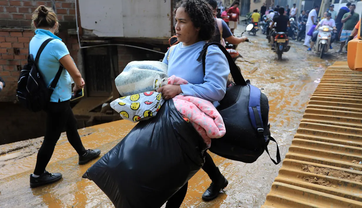 Sebagian warga menyelamatkan diri bersama barang bawaan. (JAIME SALDARRIAGA/AFP)