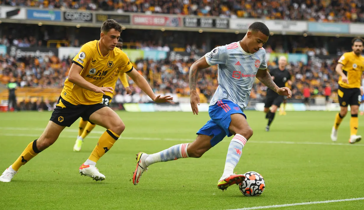 Bek Wolverhampton Wanderers Max Kilman (kiri) menantang striker Manchester United (MU) Mason Greenwood pada match day ketiga Liga Inggris di Stadion Molineux, Minggu (29/8/2021). MU menang tipis 1-0 lewat gol Mason Greenwood. (Oli SCARFF/AFP)