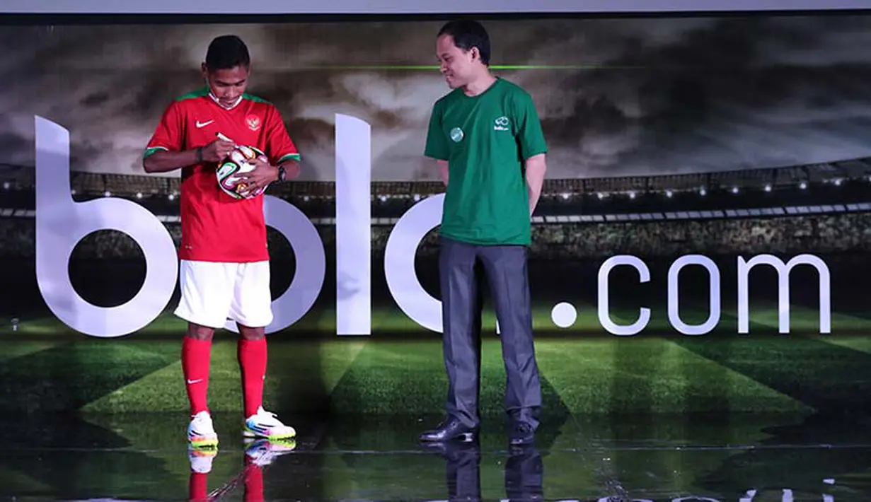 Pemain Timnas Indonesia yang memperkuat Persija Jakarta Ramdani Lestaluhu sedang menandatangani bola disaksikan langsung CEO KMK Adi Sariaatmadja saat syukuran peluncuran bola.com. (Arief Bagus/bola.com)