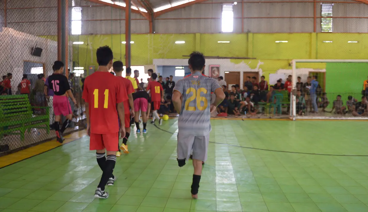 Seorang kiper, Eman Sulaeman bersama rekan-rekannya meninggalkan lapangan seusai pertandingan futsal di Indramayu, 3 Februari 2018. Lewat kiprahnya di ranah sepak bola, Emang ingin terus menginspirasi atlet dengan disabilitas lainnya. (ADEK BERRY/AFP)