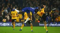 Bek Chelsea, Antonio Rudiger, berebut bola dengan striker Wolverhampton, Raul Jimenez, pada laga Premier League di Stadion Molineux Wolves, Kamis (5/12). Wolves menang 2-1 atas Chelsea. (AFP/Geoff Caddick)